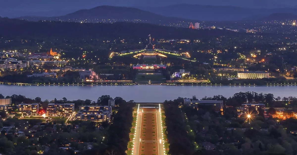 Canberra’s Lake Burley Griffin at dusk with city lights and Parliament House