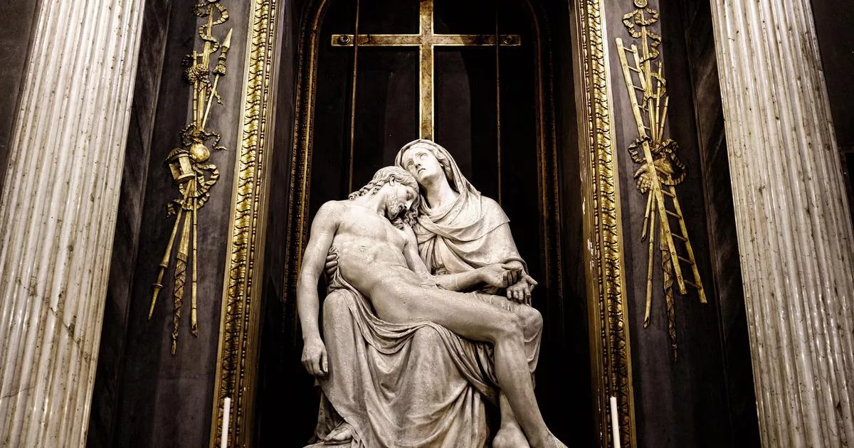 Jesus sculpture in Milan cathedral with golden cross backdrop
