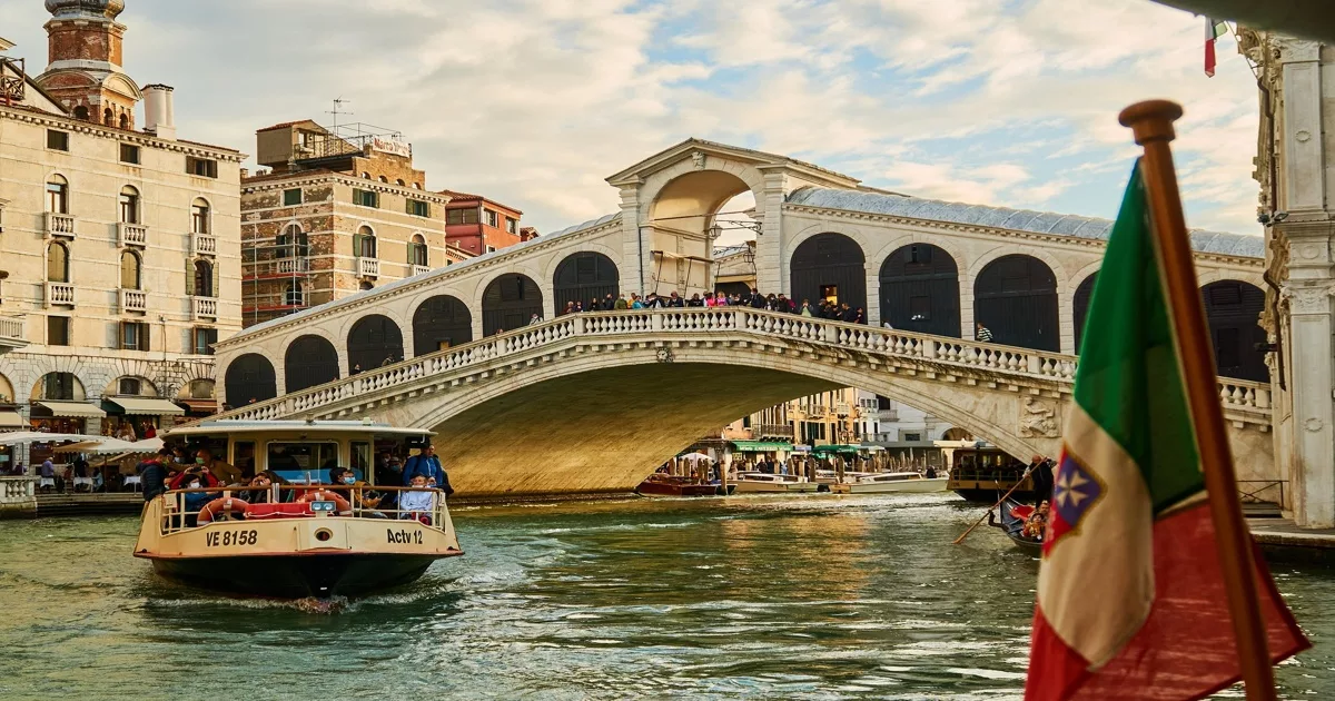 Rialto Bridge in Venice with boat passing below on Grand Canal