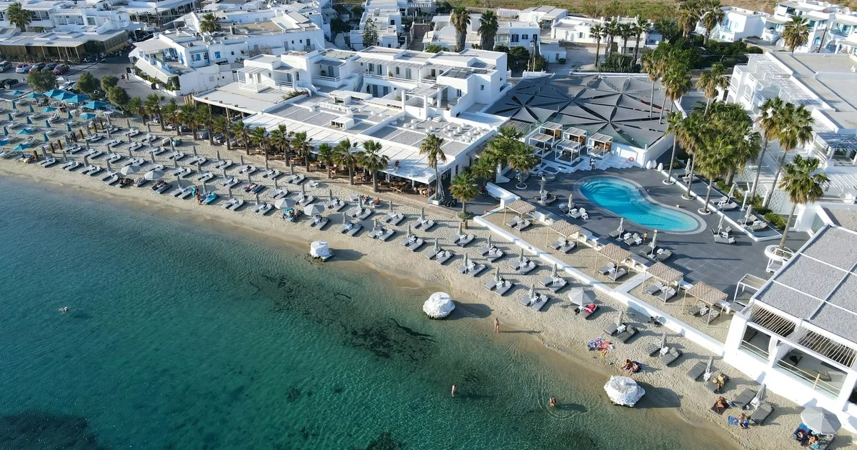Aerial view of Mykonos beach lined with umbrellas and turquoise waters in Greece