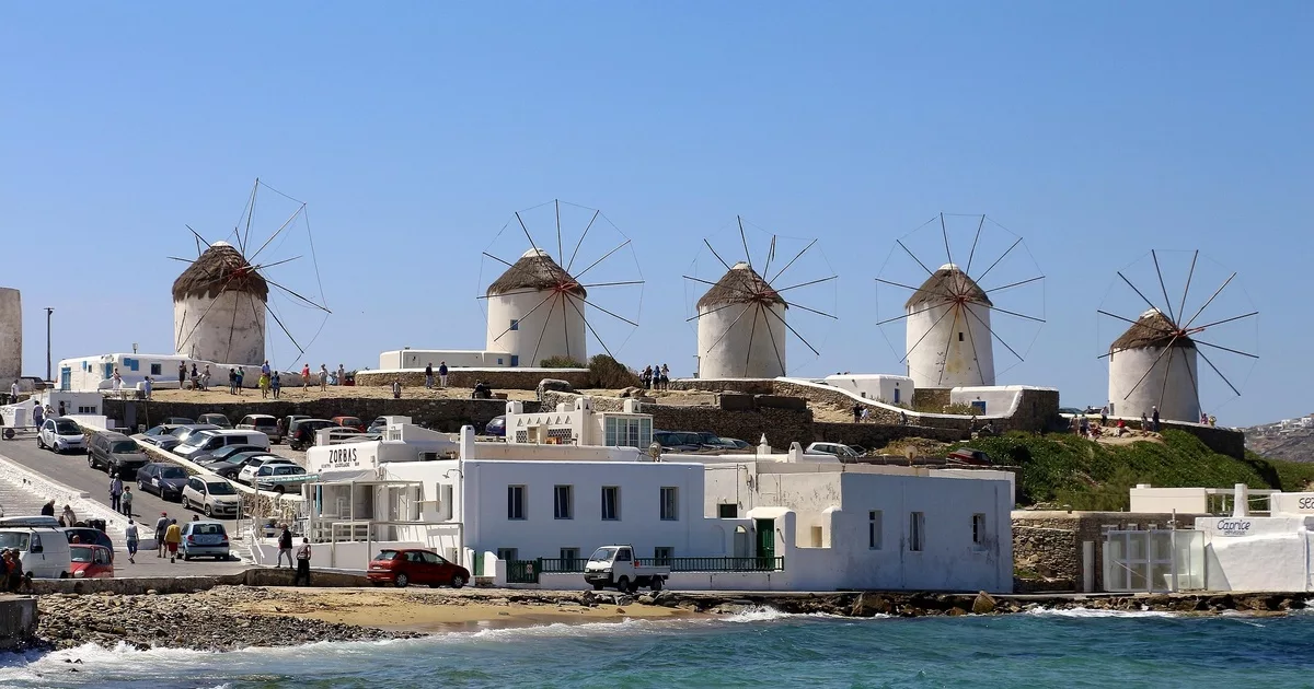 Iconic windmills overlooking Mykonos Old Town and the Aegean Sea in Greece